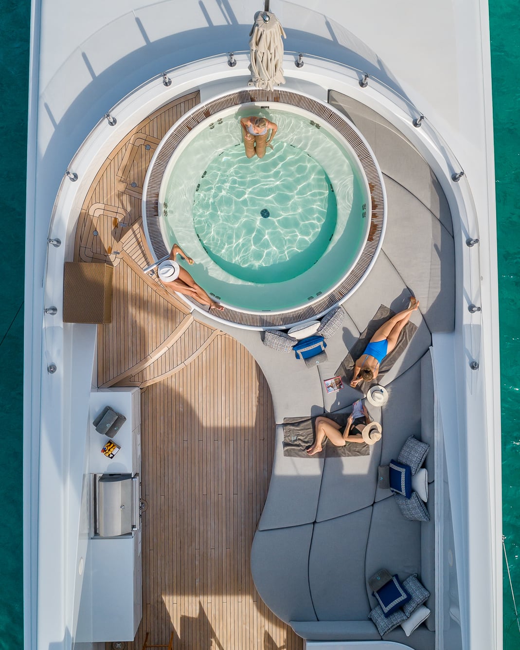 Aerial view of a superyacht deck and jacuzzi in turquoise water