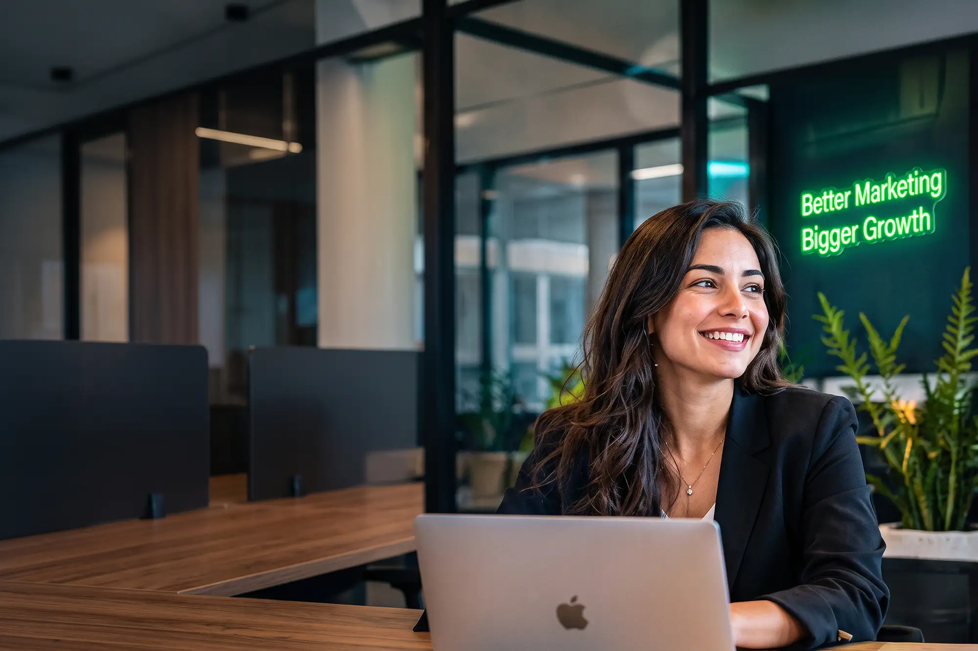 Smiling marketer working on a laptop in the DSNMRK office