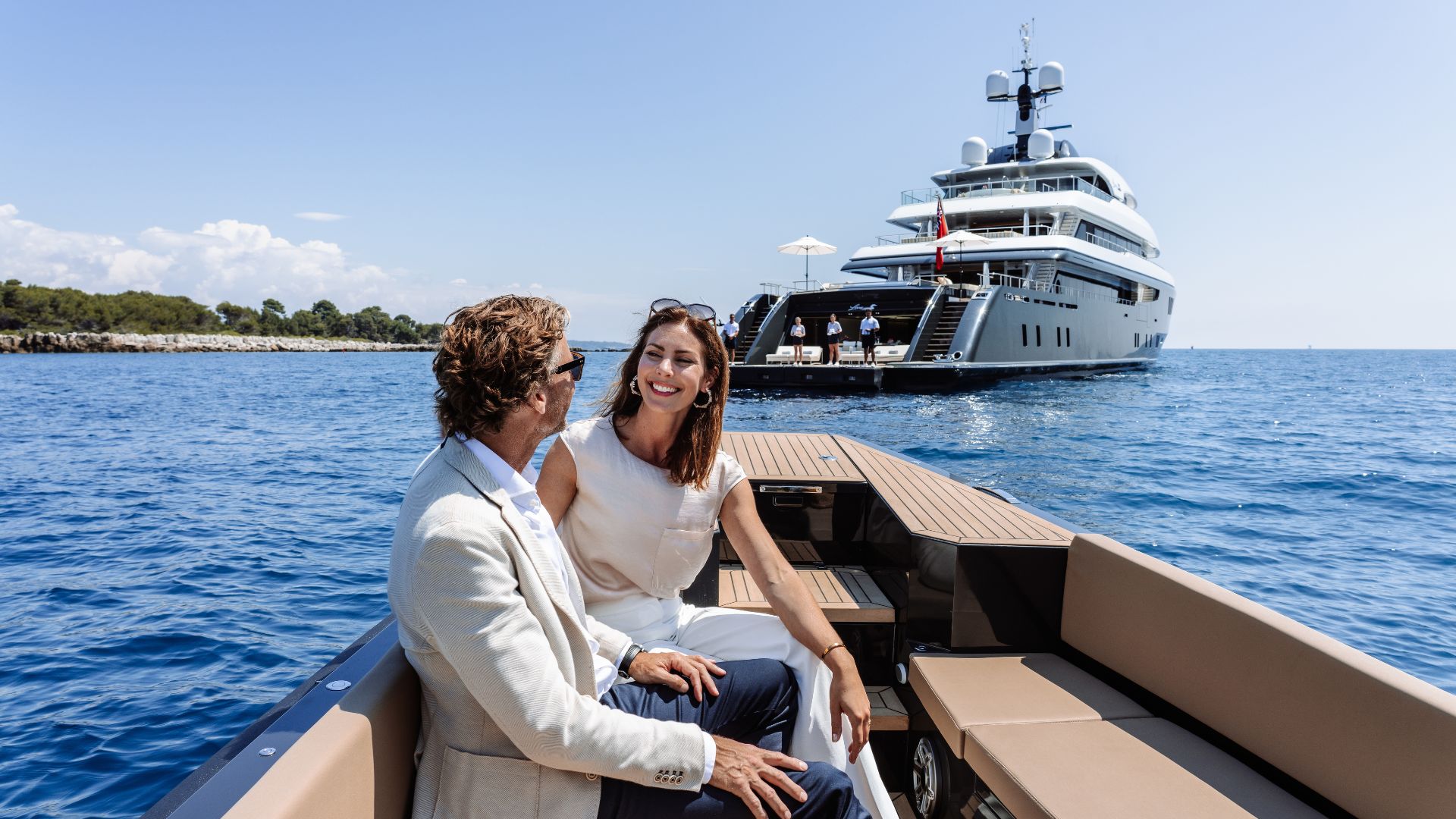 Guests on a chase boat with an IYC superyacht at anchor